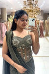 Close-up of a designer sheer corset blouse featuring pure handwork crystal and bead embroidery, paired with a pleated metallic shimmer drape for cocktail parties.