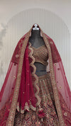 Deep maroon heritage bridal lehenga on a mannequin featuring antique gold zari, heavy dark red zarkan highlights, and a double dupatta styling. urban dulhaniya, pune