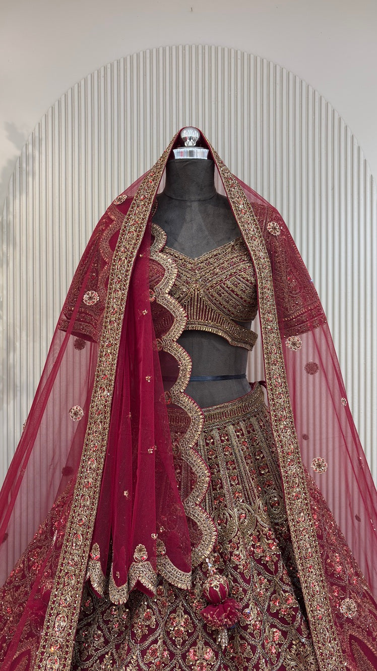 Deep maroon heritage bridal lehenga on a mannequin featuring antique gold zari, heavy dark red zarkan highlights, and a double dupatta styling. urban dulhaniya, pune