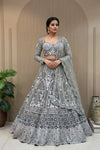 Luxury Pewter Grey bridal lehenga with cutdana, beads, zarkan highlights and heavy silver patti embroidery, featuring a corset-style full-sleeved blouse and scalloped net dupatta.
