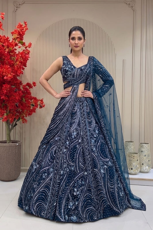 Midnight navy designer lehenga on a model featuring heavy hand-embroidery with cutdana, sequins, and metallic beads, paired with a modern sleeveless V-neck blouse.