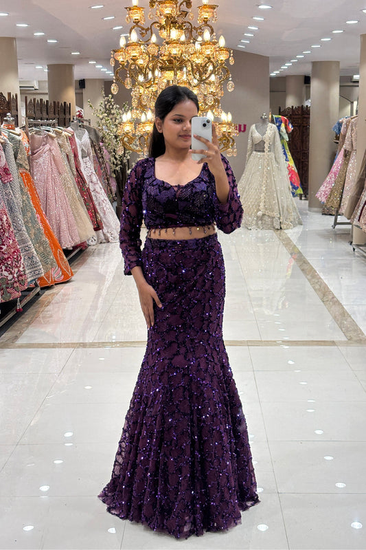 Full-length view of a woman wearing a luxury violet fishcut Indo-Western lehenga with heavy sequin embroidery for cocktail parties.
Full-body mirror selfie showcasing a glamorous deep purple mermaid lehenga silhouette at the MG Road, Pune boutique.